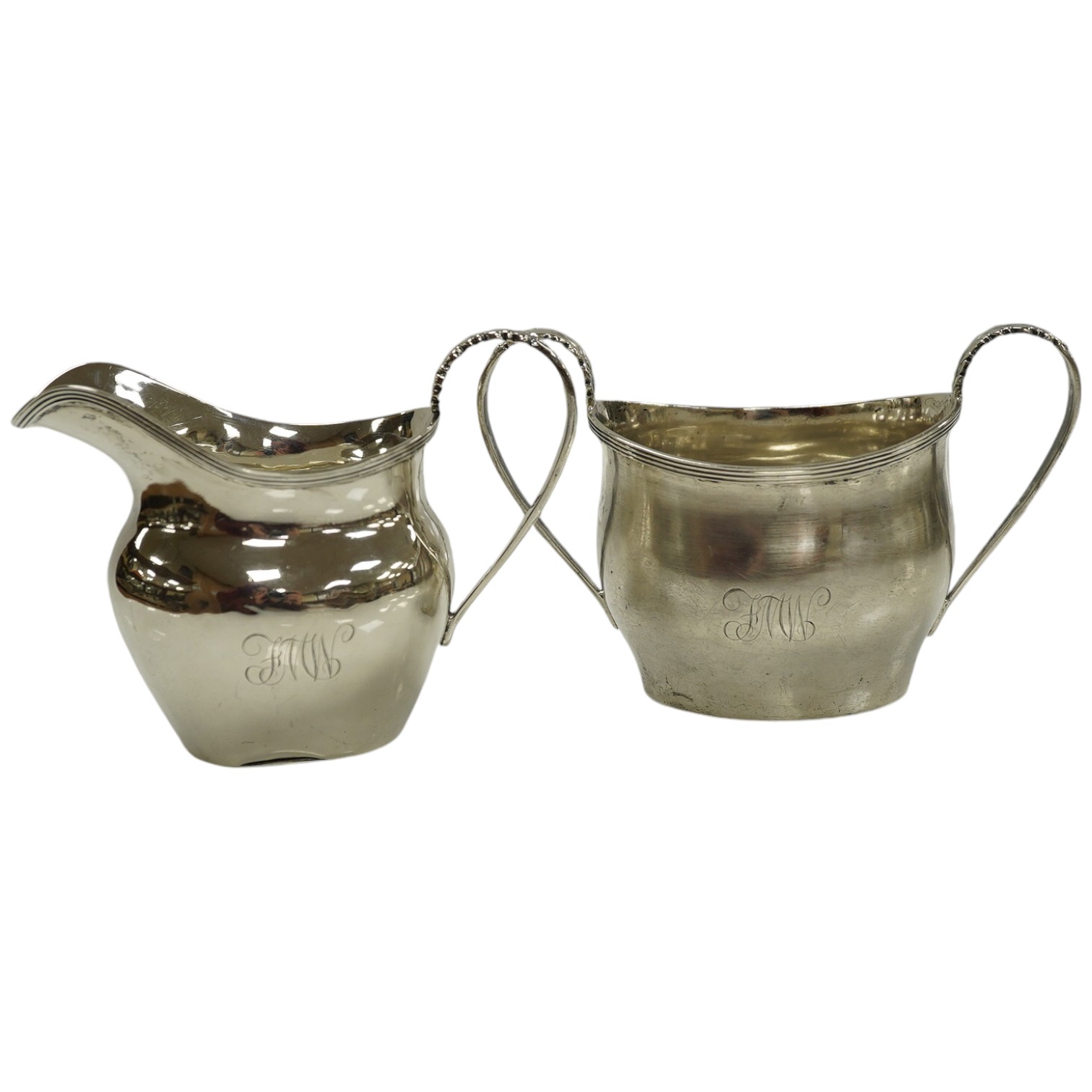 An Edwardian silver cream jug and sugar bowl, Nathan & Hayes, Chester, 1906?, 6.4oz. Condition - poor to fair